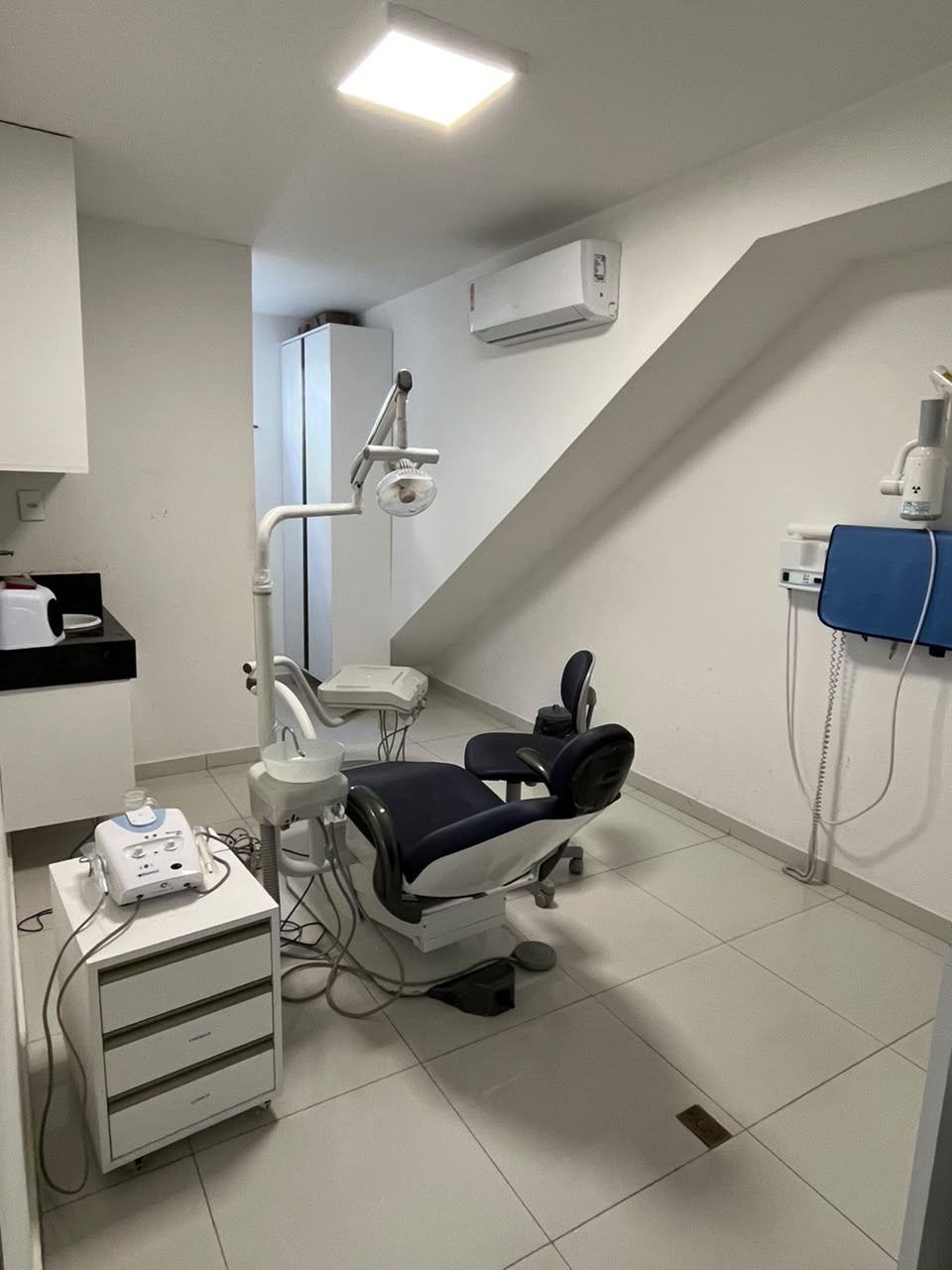 Consultório com cadeira odontológica e aparelho de raio-X